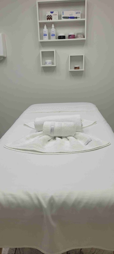Sala de atendimento da Ana Maria Estética Avançada, com maca e prateleira de produtos